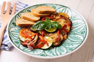 Baked vegetables with toasts. Italian dish.