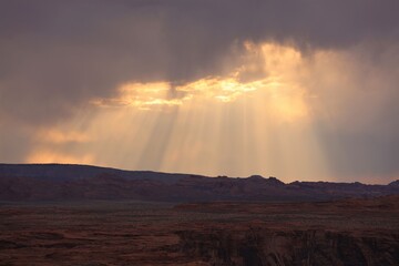 Rays of Sun Shining Through Clouds on the Horizon Behind Horseshoe Bend Near Page, Arizona
