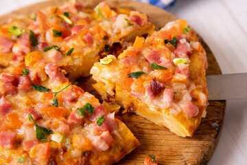 Spanish omelette with potatoes, zucchini and ham on top. Traditional tapa from southern Spain.