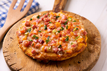Spanish omelette with potatoes, zucchini and ham on top. Traditional tapa from southern Spain.