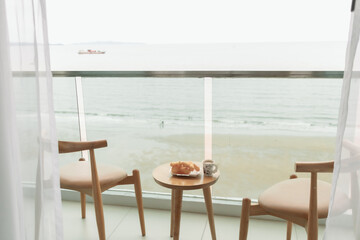 Table and chairs on the balcony with sea view. Summer travel concept.