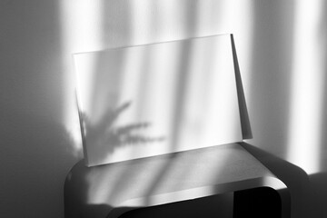 Blank canvas mockup on shelf on wall with shadows. White cotton canvas