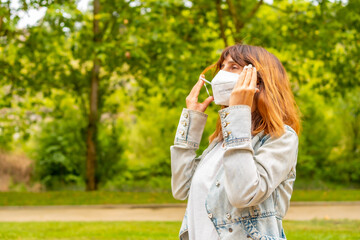 A young woman removing her surgical mask at the end of the coronavirus pandemic. End of...