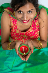 Portrait of a Indian Traditional Girl holding Diya, Girl Celebrating Diwali or Deepavali with...