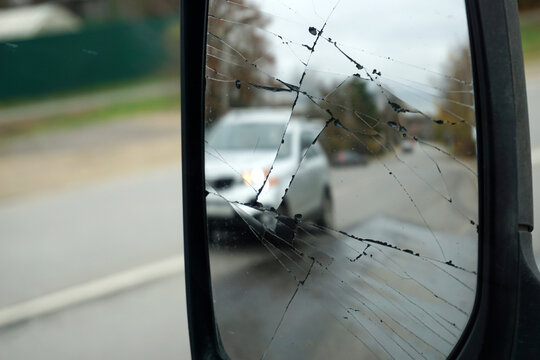 Close-up rear view mirror with lots of cracks. Bad luck, possible accident.