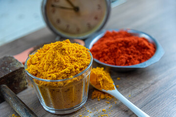 Colorful culinary spices and clock on wooden surface