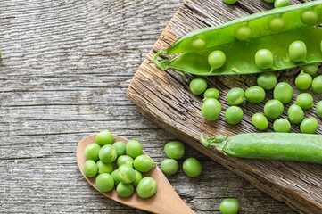 Fresh green peas with pod on wooden  background, healthy green vegetable or legume ( pisum sativum )