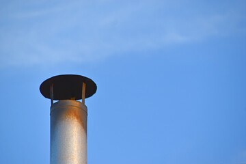 Iron chimney on the roof of the house