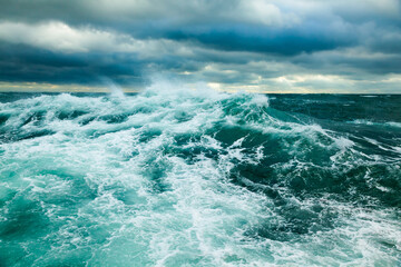 Heavy storm in the ocean. Large waves in the open sea and cloudy sky during a storm.