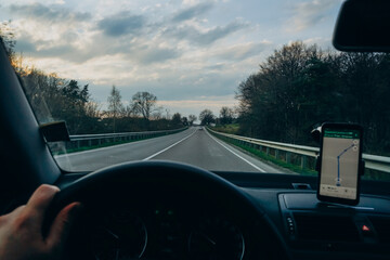 Hands on the steering wheel on the road background. A man behind the wheel travels on a background...