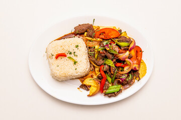 Tray of sauteed beef tenderloin cooked with Peruvian recipe with white rice, french fries and sauteed vegetables with soy sauce
