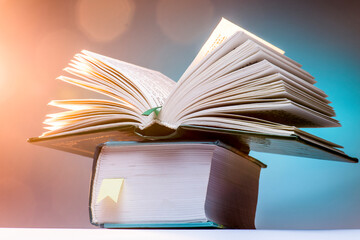 Open book on a blue background, bright surroundings.