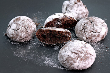 Chocolate chip cookies sprinkled with powdered sugar. Homemade round biscuits with cocoa and gluten-free powdered sugar.