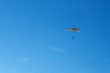 Hang glider with motor in the blue sky on landing