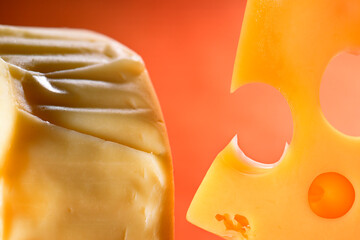 Swiss cheese with holes on an orange background.