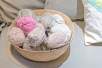 Fototapeta na wymiar Multicolored skeins of yarn in a wicker basket for knitting and needlework.
