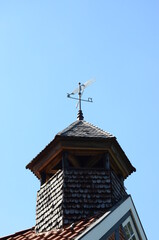 weather vane on the roof top of a tower under sun light