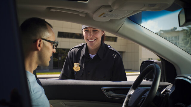 Friendly Police Officer Checking Driver License Of Man