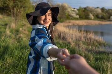 Girl in a hat on the nature by the lake.