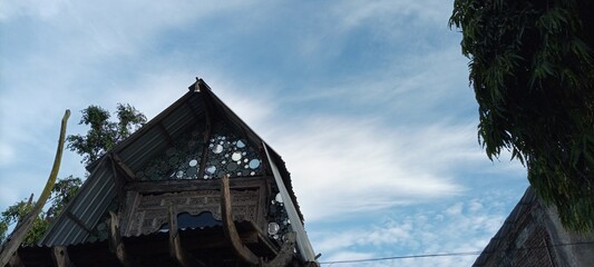 bird house on old wooden tree on cloudy blue sky