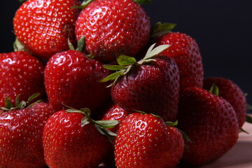 horizontally oriented image, close-up of a small pile of berries, ripe fresh strawberries 