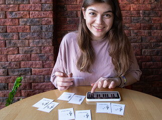 The girl studies notes and music theory using special cards.
