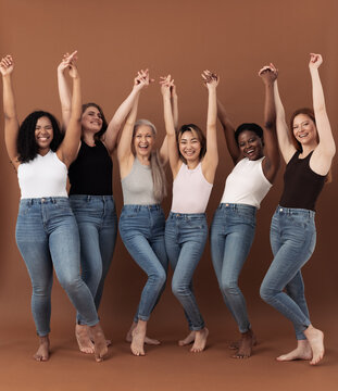 Six happy women raised their hands up together over brown background