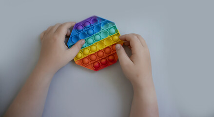 the child's hands are holding an antistress toy
