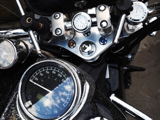 Dashboard of a black motorcycle located on the handlebars and body. Closeup photo