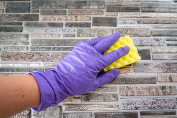 Detergent for walls. A man washes the wall with gloves.