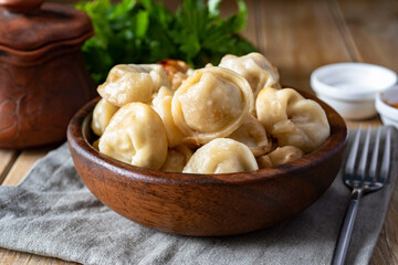 A hearty meal for the family: fried dumplings with meat in a wooden bowl on a wooden table.