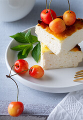 Cottage cheese casserole and sweet cherry on wooden light table. Cottage cheese casserole