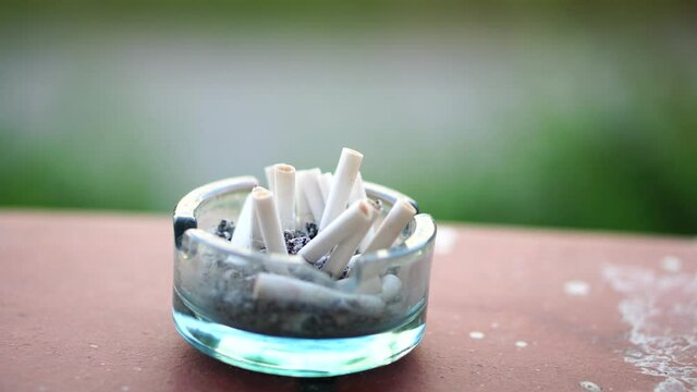 Glass ash tray full of used cigarett