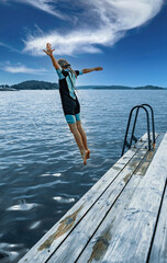 Fototapeta na wymiar teenager joyfully jumping into the sea