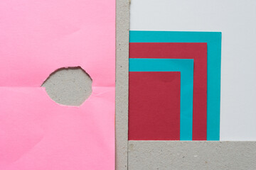 torn paper composition in turquoise blue, deep red, pink, and mill board with space for text