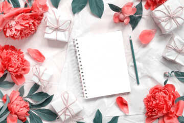 Bouquet of beautiful delicate pink peonies with vintage wrapping paper and  notebook for text  on background. Minimal concept backdrop.  Conceptual spring banner.