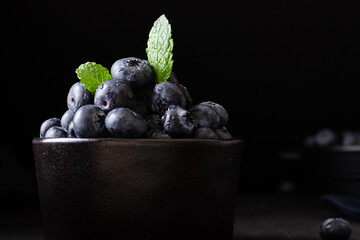 Blueberries in bowl dark background