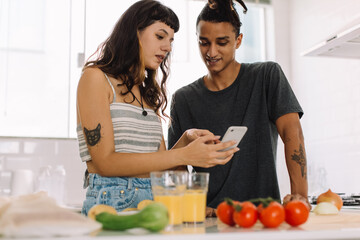Adorable young couple following an online recipe
