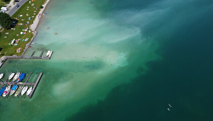 Luftaufnahme mit einer Drohne vom Plansee mit Wasserverfärbungen, die durch die Badegäste entstanden sind