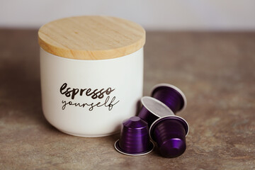 Espresso coffee capsules, pods with coffee cannister on plain background