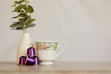 Espresso coffee capsules, pods on plain background with tea cup