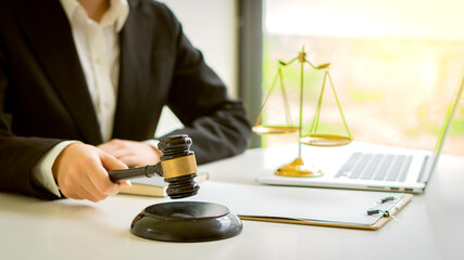 Lawyers work with contract documents and hammer with scales and laptops on the courtroom table. justice and law court judge concept