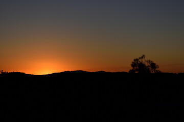 Sun setting behind mountain range