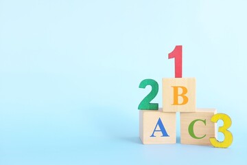 Colorful 123 numbers and abc letters alphabet on wooden blocks in blue background with copy space. Start of child or kid learning counting concept. - obrazy, fototapety, plakaty