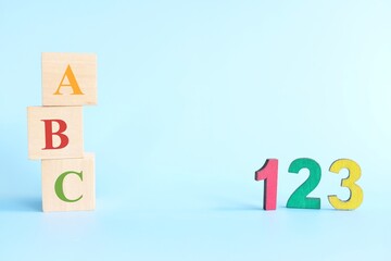 Colorful 123 numbers and abc letters alphabet on wooden blocks in blue background with copy space....