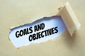 Goals and Objectives words written under torn paper.