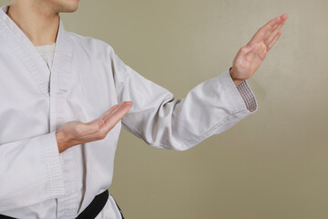 Close up shot of male body part performing taekwondo double knife hand position. Neutral background with copy space for text.