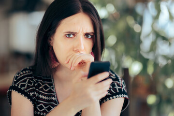 Fototapeta na wymiar Worried Sad Woman Reading Text Message on her Phone