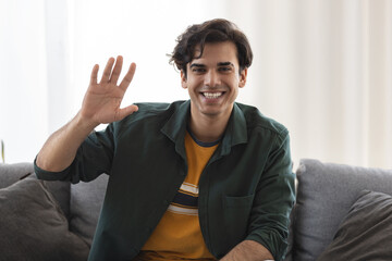 Headshot of smiling caucasian man looking at the camera and waving hello, video call with friend or...
