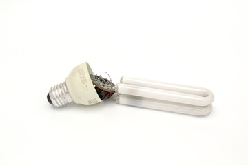 Burnt out lamp on isolated white background. An old lamp is broken so you can see the circuit board and other components